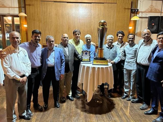 Officials gathered around a gold cup on a table in a hall