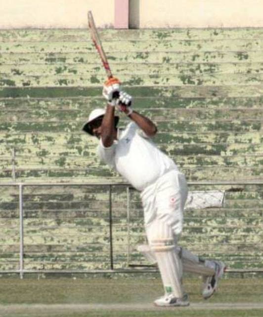 A batsman playing a shot in an old photograph