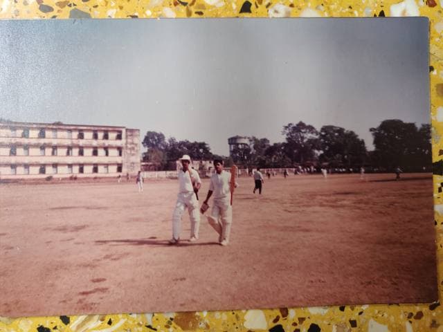 Two batsmen walking on a bare ground in an old photograph