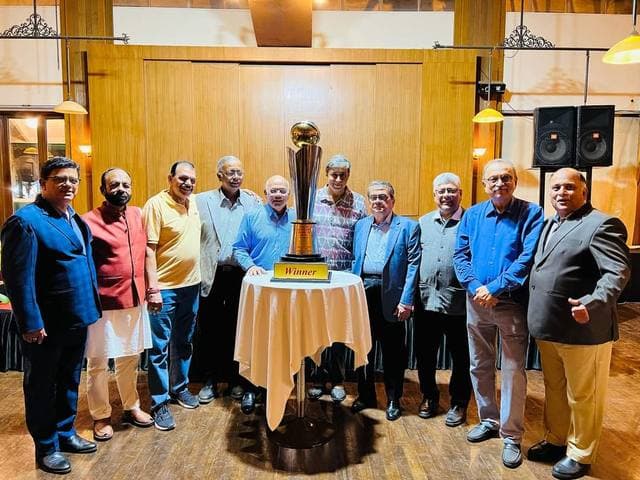 Officials standing around a gold cup on a table in a hall