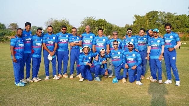 A team in blue and pink kit lined up on a ground