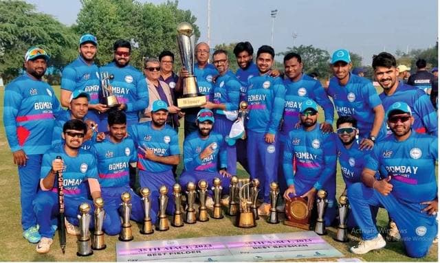 A team in blue kit holding a gold cup among rows of trophies
