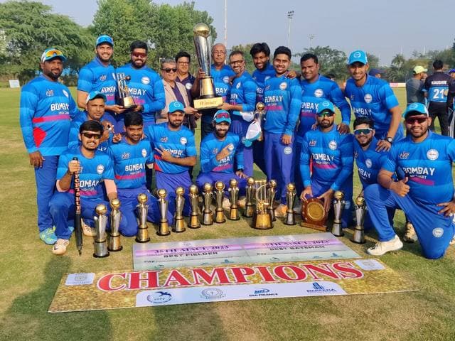 A team in blue kit holding trophies behind a Champions banner