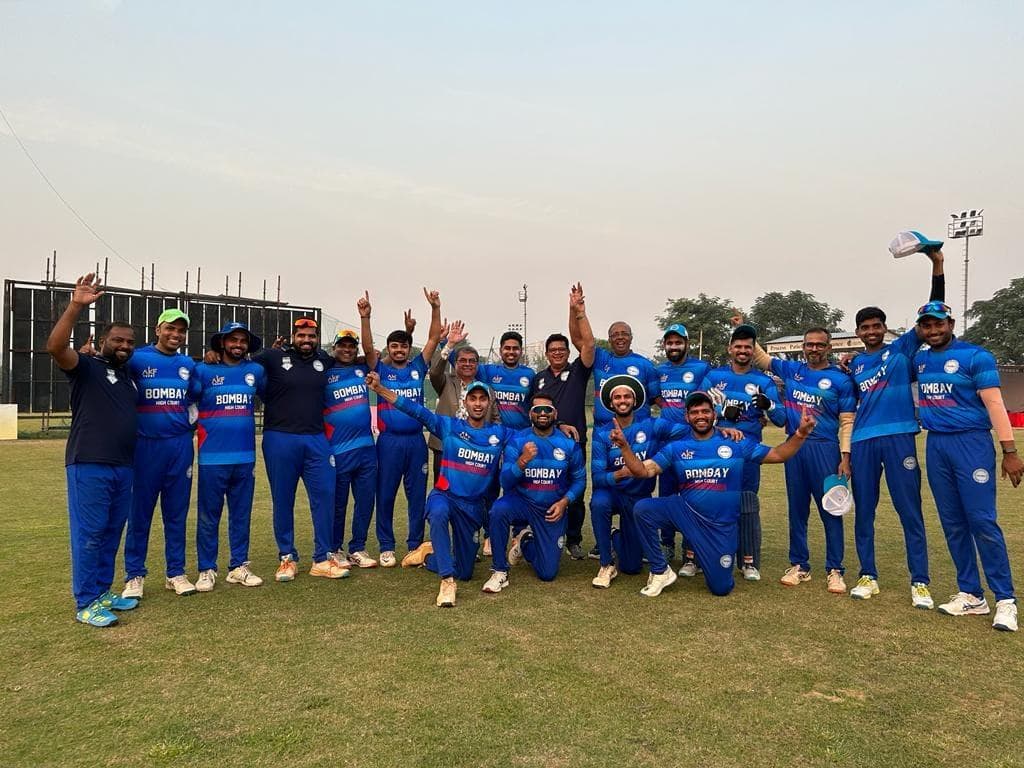 A team in blue kit with arms raised at dusk