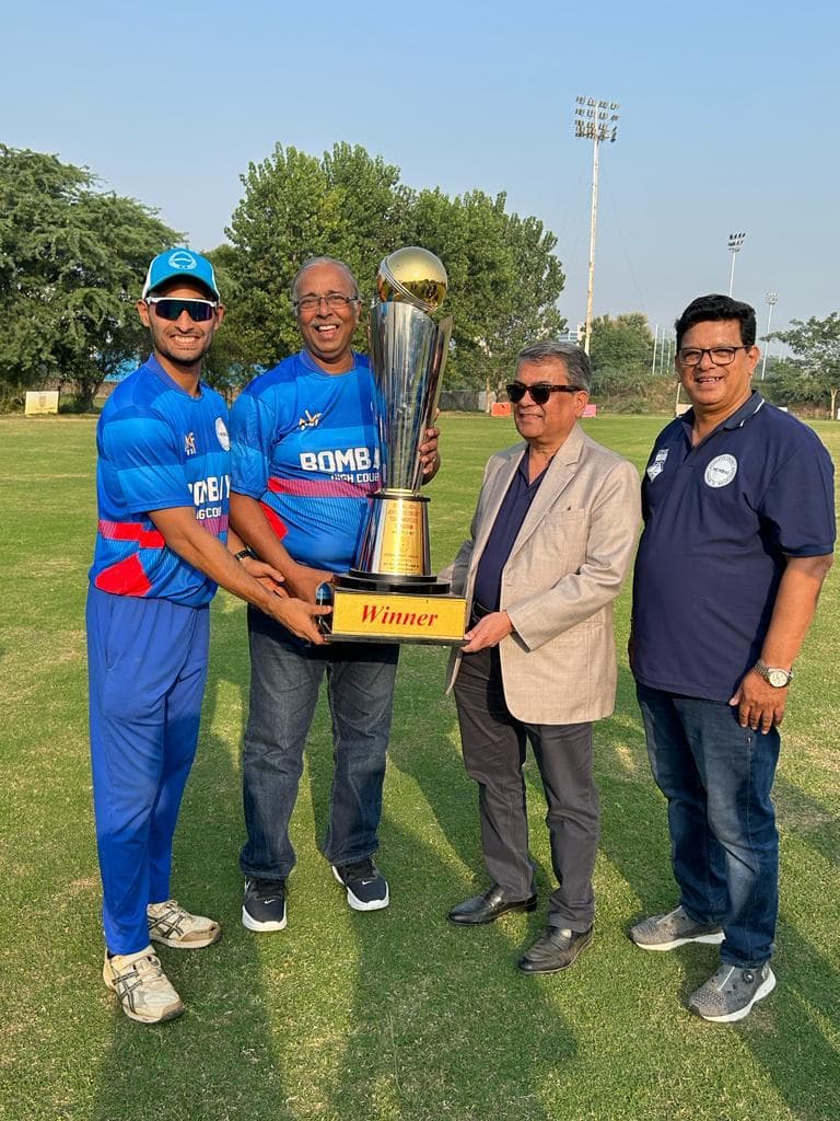 Players and an official holding a gold cup labelled Winner